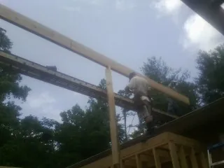 Carpenter setting a ridge beam over a new addition frame — Ice Dam Removal by Roofing Brothers in Vidor
