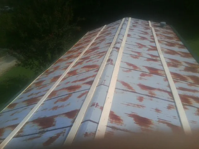 Rusted metal roof panels with new wood purlins before replacement — Storm Damage Roof Repair in Vidor by Roofing Brothers