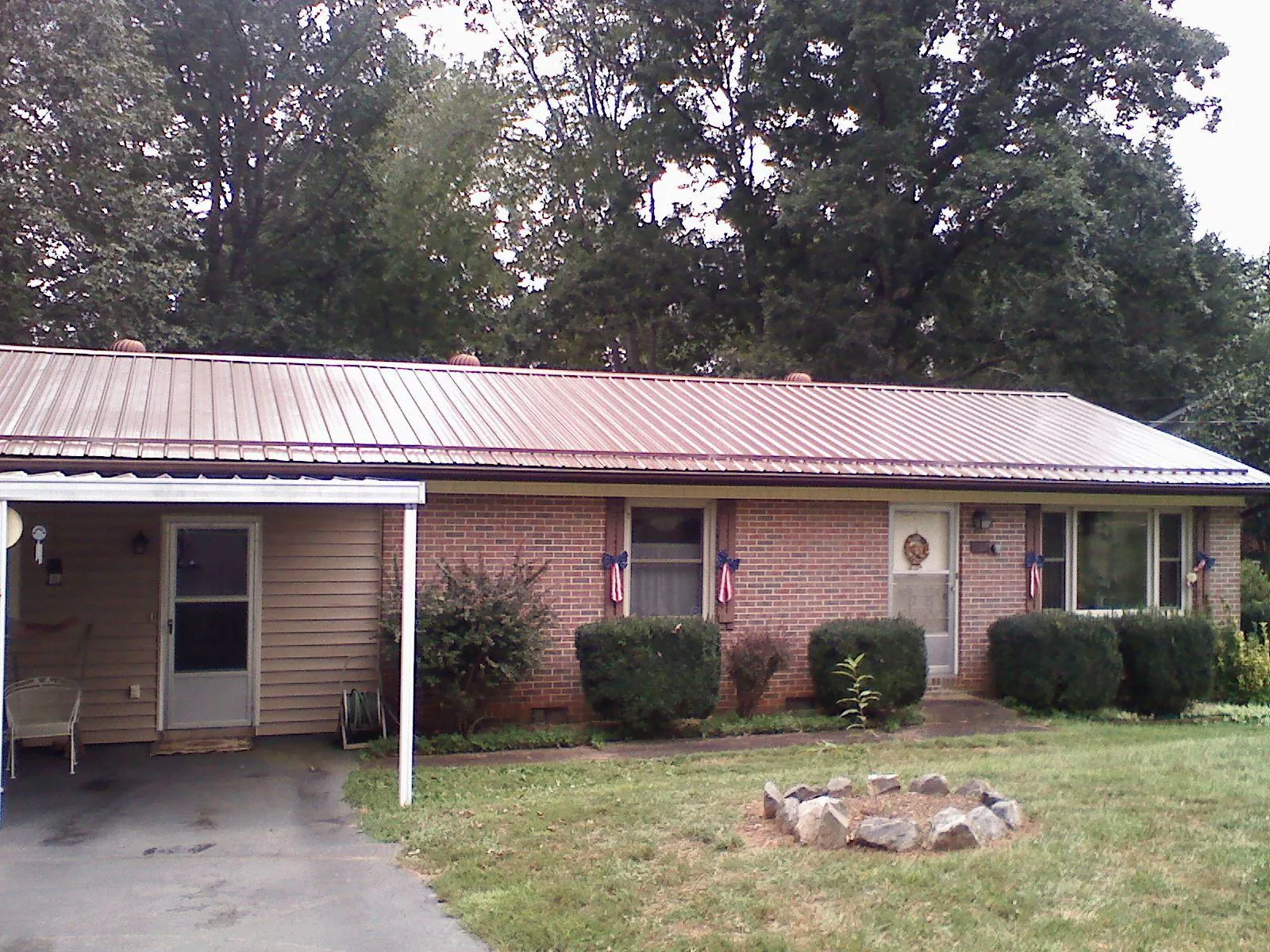 Bronze metal roof and carport on a brick ranch home — Roof Repair work by our crew in Vidor