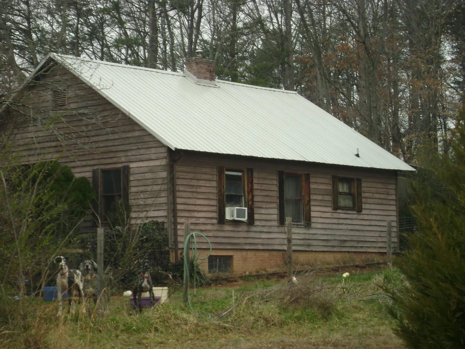 White metal roof on an old wood sided farmhouse, from a Metal Roof Installation job in Vidor